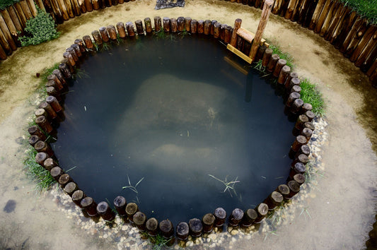 "De Nijmeegse watersteen by Erik Odijk, a LandArt installation depicting a pre-historic temple garden dedicated to Nehalennia, the water goddess of the Netherlands, using chestnut poles, yellow gravel, white sand, and grass, with rising water levels in winter."